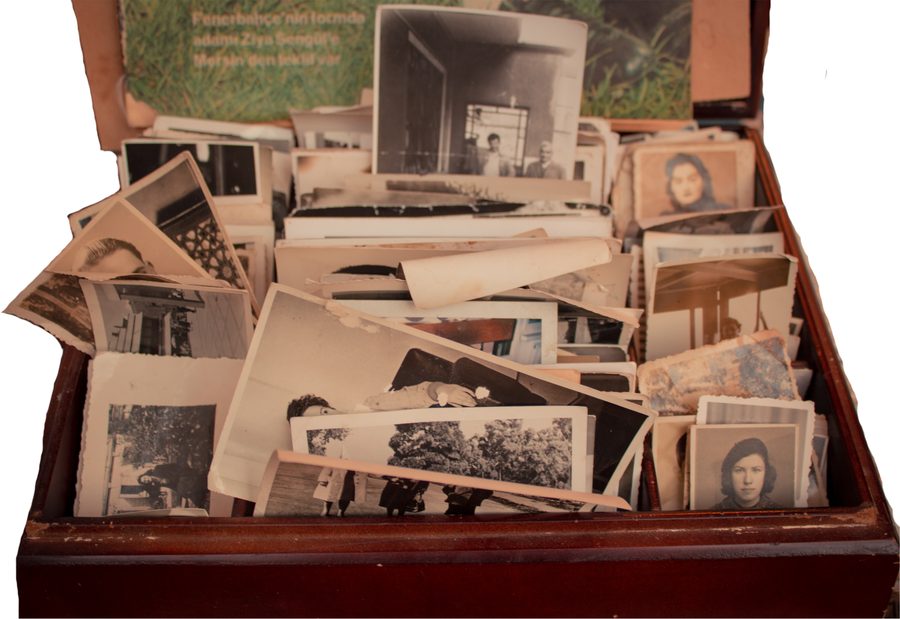 An open box overflowing with old, unlabeled family photographs